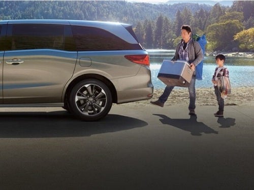 2024 Honda Odyssey view of man and boy loading ice chest in cargo area using handsfree liftgate