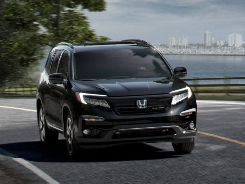 2024 Honda Pilot driving on a road outside a city