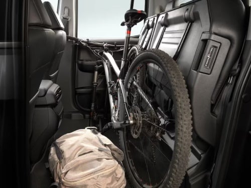 2024 Honda Ridgeline side interior view of back seats up with bike and bag in cargo space 