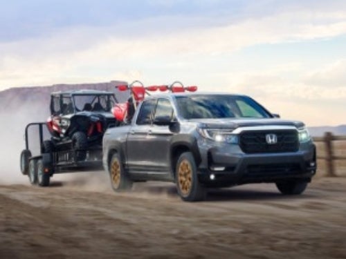 2024 Honda Ridgeline towing a side-by-side on a trailer