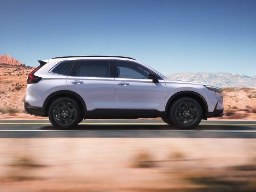 2025 Honda CR-V side view of car driving fast on a road 